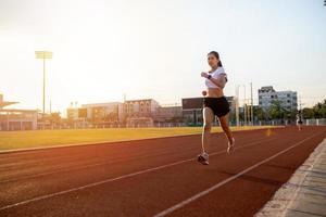 joven corredora asiática de fitness que corre en la pista del estadio -estilo de vida saludable y conceptos deportivos foto