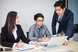 Asian businessmen and group using notebook for business partners discussing documents and ideas at meeting and business women smiling happy for working photo