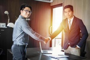 Asian Business people shaking hands and smiling their agreement to sign contract and finishing up a meeting photo