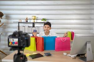 Asian man  blogger broadcasting a video for selling product online .Shopping online concept photo