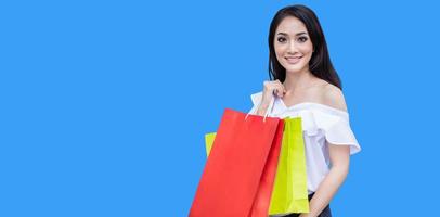 Beautiful asian young woman with shopping bags with smile while standing at the clothing store. Happiness, consumerism, sale and people concept photo