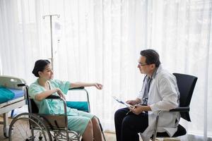 los médicos preguntan y explican sobre la enfermedad a una paciente acostada en la cama de un hospital. foto