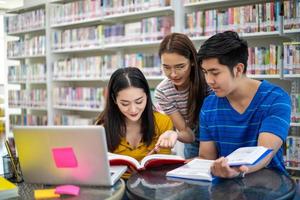 Group Asian  Students Smile and reading book and using notebook for helps to share ideas in the work and project. And also review the book before the exam photo