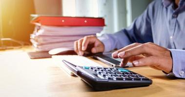 Businessmen are using calculators and analysis business data and and graph financial diagram working  at the meeting. photo