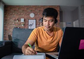 Asian businessmen is using notebook computers and wear headphones for online meetings and working from home. photo