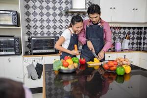 Happy and Smiling young couple cooking food in the kitchen at home photo