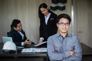 hombre de negocios asiático y grupo usando un cuaderno para reunirse y hombres de negocios sonriendo felices por trabajar foto