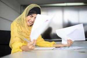 éxito de las mujeres de negocios musulmanas y concepto ganador - equipo feliz con las manos levantadas celebrando el avance y los logros foto