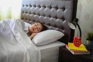 hermosa mujer asiática durmiendo en una cama blanca. foto