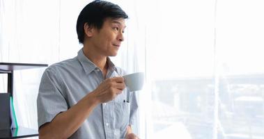 senior hombre asiático tomando café en tiempo de relajación foto