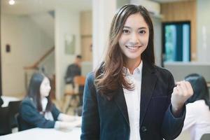 éxito de mujeres empresarias asiáticas y concepto ganador: equipo feliz con las manos levantadas celebrando el avance y los logros foto
