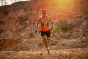 A man Runner of Trail and athlete's feet wearing sports shoes for trail running in the mountain photo