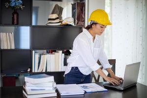 Beautiful Asian engineering women checking document and using notebook working from home for social distance and self responsibility concept photo