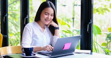 hermosas mujeres de negocios asiáticas revisando documentos y usando un cuaderno trabajando desde casa para el concepto de distancia social y responsabilidad propia