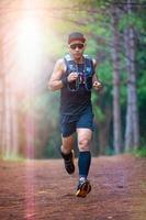 A man Runner of Trail and athlete's feet wearing sports shoes for trail running in the forest photo