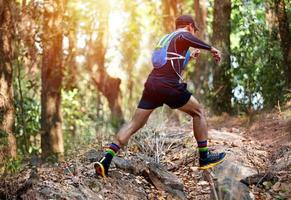 A man Runner of Trail and athlete's feet wearing sports shoes for trail running in the forest photo