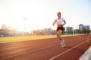 joven corredora asiática de fitness que corre en la pista del estadio -estilo de vida saludable y conceptos deportivos foto