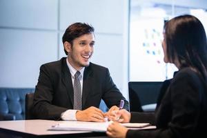 empresarios y empresarias discutiendo documentos para el concepto de entrevista de trabajo foto