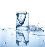 agua potable salpicada de hielo en vaso foto