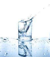 agua potable salpicada de hielo en vaso foto