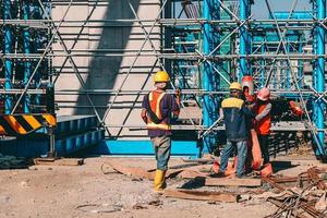 Group of construction worker with helmet working together at construction site. Indonesia, March 2022 photo