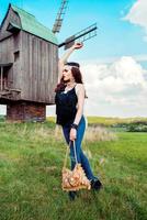 Young beautiful girl with long dark hair in green field in outdoor ethnic village in Kyiv Ukraine photo