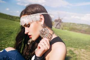 hermosa joven con el pelo largo y oscuro en el campo verde en la aldea étnica al aire libre en kiev, ucrania foto