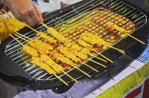 brochetas de cerdo kebab satay calle del mercado local comida hecha a mano a la parrilla foto