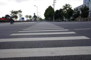 Crosswalk on the road for safety when people walking cross the street, Pedestrian crossing on a repaired asphalt road, Crosswalk on the street for safety, logistic import export and transport industry photo