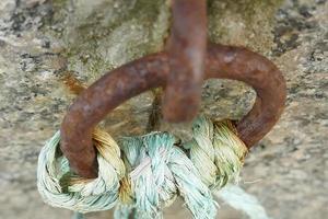 cuerda azul atada a un anillo de hierro oxidado foto