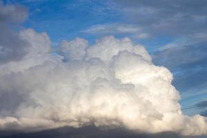 nubes blancas en el cielo azul. nube formando una gruesa capa gris uniforme. foto