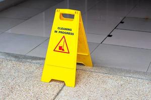 Cleaning in progress sign on concrete floor. photo