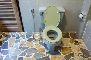 Toilet bowl with bidet shower in toilet. photo