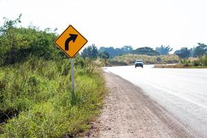 Curved road symbol traffic signs on concrete pole. Symbol for vehicles. Turn right. photo