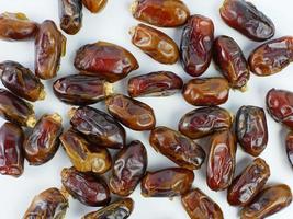 dates scattered isolated on a white background. healthy fruit ramadan concept photo