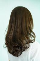 Professional hair stylist making a hair coloring and treatment in beauty and salon shop. Woman changing a hair color in professional salon shop. photo