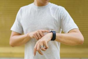 Unrecognizable Asian sportsman using smartwatch in his exercise. photo