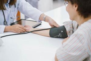 close up doctor checking senior patient blood pressure. Health care. photo