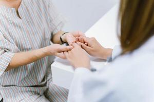 close up doctor hold hand of senior patient , medical care responsibility photo