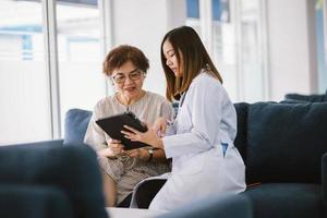 médico joven que consulta a un paciente mayor en la clínica de atención médica foto