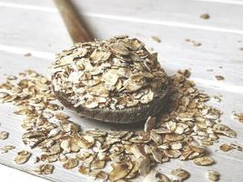 oatmeal or coarse oats on wooden spoon photo