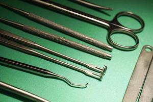 surgical instruments on green hospital drape photo