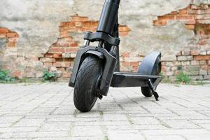 Electric kick scooter or e-scooter parked on pavement photo