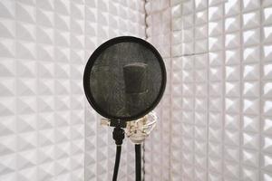 microphone on mic stand in soundproof isolation booth for vocal recording at sound studio photo