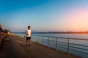 Man running on street with a view of river in the morning. photo
