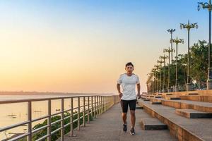 Man running on street with a view of river in the morning. photo