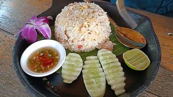 arroz frito con huevo en un plato negro y guarniciones foto