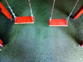 Set of brown wooden swings on artificial turf. photo