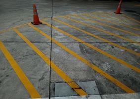 líneas de tráfico amarillas y conos naranjas, áreas de estacionamiento prohibido. foto