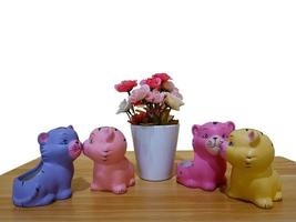 pequeñas figuras plásticas de gatos de colores construidas y flores en la mesa foto